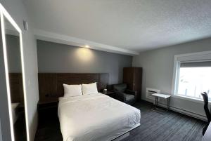 A bed or beds in a room at Travelodge by Wyndham Regina