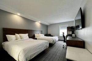 a hotel room with two beds and a television at Travelodge by Wyndham Regina in Regina