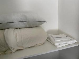 1 cama blanca con almohadas en un estante blanco en Solar de la Abadia 2 Amb en Buenos Aires