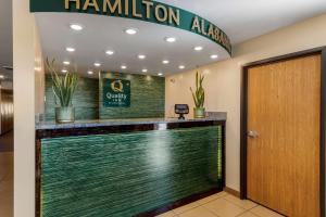 um átrio do hotel com um balcão de recepção com uma placa hotelulumulum em Quality Inn em Hamilton