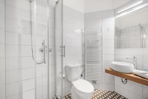 a white bathroom with a toilet and a sink at Downtown Bratislava B&B in Bratislava