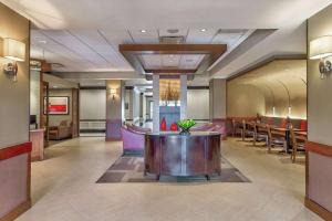 eine Lobby eines Hotels mit einem Tisch und Stühlen in der Unterkunft Wyndham Garden Kansas City Airport in Kansas City