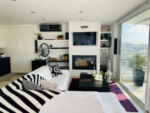 ein Wohnzimmer mit einer weißen Couch und einem Kamin in der Unterkunft Sea View Luxury Studio Palaio Faliro in Athen