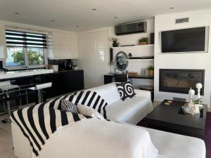 a living room with a white couch and a tv at Luxury Penthouse Studio with Sea View, Palaio Faliro in Athens