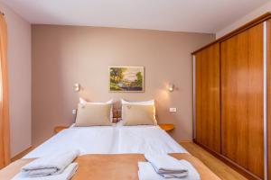 a bedroom with a bed with two towels on it at Apartman Ana in Krk