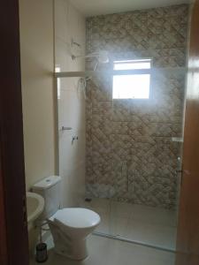 a bathroom with a toilet and a shower with a window at Acomodação corporativa: casa residencial recém-construída in Itatiba