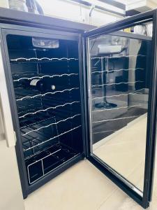 einen Kühlschrank mit offener Tür und leeren Regalen in der Unterkunft Sea View Luxury Studio Palaio Faliro in Athen