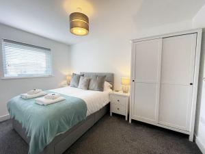 ein Schlafzimmer mit einem großen Bett und einem weißen Schrank in der Unterkunft 33 Ocean one in Newquay