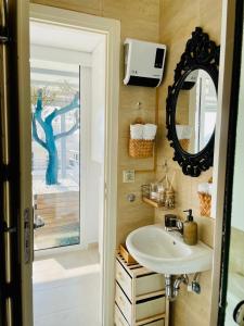 ein Bad mit einem Waschbecken und einem Spiegel in der Unterkunft Sea View Luxury Studio Palaio Faliro in Athen