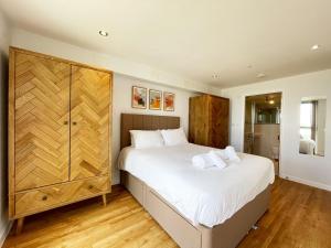 a bedroom with a large bed and a wooden cabinet at 38 Zinc in Newquay