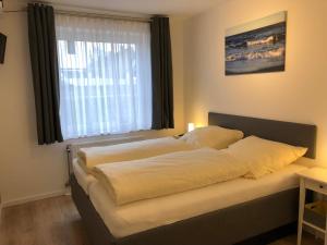 a bed in a room with a window at DKK9c Ferienwohnung Ostsee-hn-sucht F in Niendorf