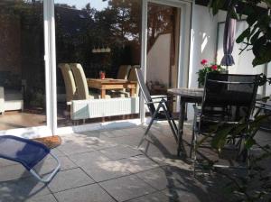 patio con sedie e tavolo sul portico di MEI2c Ferienwohnung Landkrabbe F a Niendorf