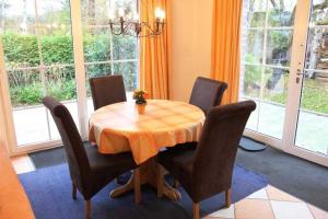 comedor con mesa, sillas y ventanas en BIR9b Ferienwohnung Vahle en Niendorf
