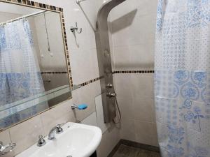 y baño con lavabo y ducha. en Alvarado Apart en Salta