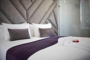 a bedroom with a bed with towels on it at Lefa Boutique Hotel in Rustenburg