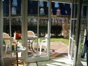 een open deur naar een patio met een tafel en stoelen bij OST1 Ferienwohnung Lörper in Niendorf