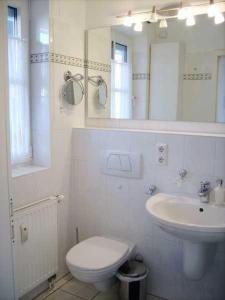 een witte badkamer met een toilet en een wastafel bij OST1 Ferienwohnung Lörper in Niendorf