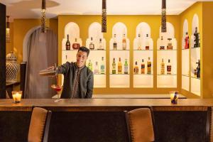a man standing behind a bar with a glass of wine at Kasbah Tamadot in Asni