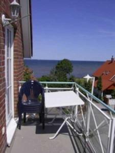 een persoon die op een stoel op een balkon zit bij OST29 Ferienwohnung Komoran in Niendorf