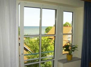 een kamer met een raam met uitzicht op de oceaan bij OST29 Ferienwohnung Komoran in Niendorf