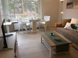 uma sala de estar com um sofá e uma mesa em ROD32a Ferienwohnung Muschelfischer F em Niendorf