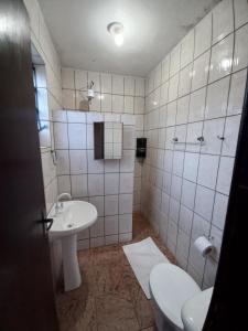 a white bathroom with a sink and a toilet at Recanto Boa Vista in Joinville