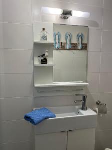 La salle de bains blanche est pourvue d'un lavabo et d'un miroir. dans l'établissement STOE12c Ferienhaus Sonne, Wohnung Sonnenschein, à Niendorf