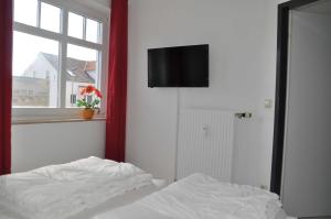 ein Schlafzimmer mit einem Bett und einem TV an der Wand in der Unterkunft STR123L Ferienwohnung Sarah in Niendorf