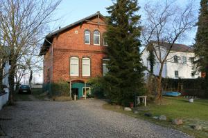 ein Backsteinhaus mit einem Baum davor in der Unterkunft STR81b Ferienwohnungen Steinmetz - Landseite in Niendorf