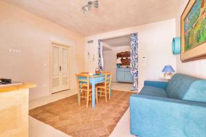 - un salon avec un canapé bleu et une table dans l'établissement Tenuta Anna by BarbarHouse, à Avetrana