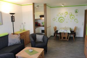 uma sala de estar com mesa e cadeiras e uma cozinha em TRA7e Residenz Windrose, App 13 em Niendorf