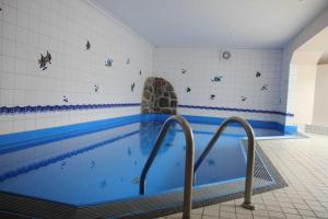 uma piscina com água azul num quarto em TRA7e Residenz Windrose, App 13 em Niendorf