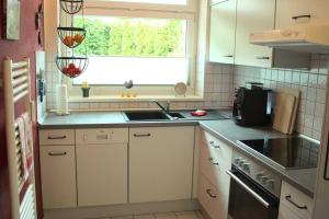 Elle comprend une petite cuisine avec un évier et une fenêtre. dans l'établissement TRA2a "Residenz Niendorf" - Kriewall F, à Niendorf