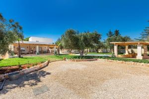 a garden with a pavilion and a building at Tenuta Anna by BarbarHouse in Avetrana