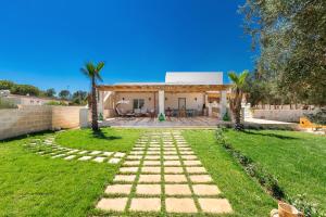a garden with a stone path in front of a house at Tenuta Anna by BarbarHouse in Avetrana