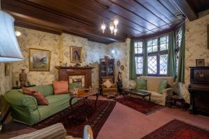 a living room with a green couch and a fireplace at StayVista at Northwood Cottage with Vintage Luxury in Shimla