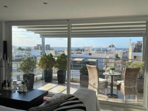ein Wohnzimmer mit einem Balkon mit Stadtblick in der Unterkunft Sea View Luxury Studio Palaio Faliro in Athen