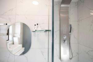 La salle de bains est pourvue d'une douche avec un miroir et un lavabo. dans l'établissement Lefa Boutique Hotel, à Rustenburg