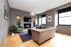 sala de estar con sofá y chimenea en ALTIDO Luxury 2BR home on George Street, en Edimburgo