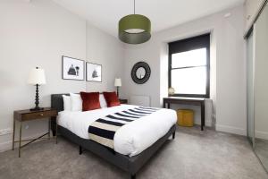 a bedroom with a large bed and a window at ALTIDO Luxury 2BR home on George Street in Edinburgh