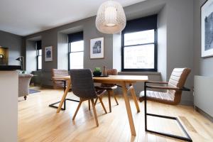 a dining room with a wooden table and chairs at ALTIDO Luxury 2BR home on George Street in Edinburgh