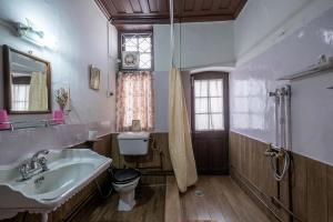 a bathroom with a sink and a toilet and a window at StayVista at Northwood Cottage with Vintage Luxury in Shimla
