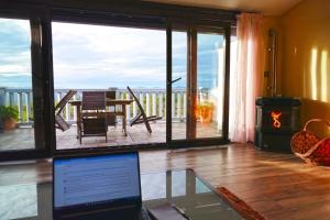 Habitación con balcón y ordenador portátil en una mesa de cristal. en El Triskel de Chumbea, alojamiento excepcional con maravillosas vistas a 5km de Béjar, en Navalmoral de Béjar