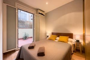 バルセロナにあるApartEasy - Central Gracia Apartmentsのベッドルーム1室(ベッド2台、大きな窓付)