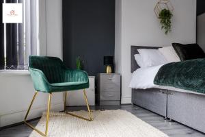 a bedroom with a green chair next to a bed at Immaculate 4 bed in Liverpool By Hinkley Homes Short Lets & Serviced Accommodation in Liverpool