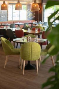 卡斯泰特的住宿－The Originals City, Hôtel Les Bruyères, Dax Nord (Inter-Hotel)，一间在房间内配有桌椅的餐厅