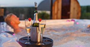 Duas taças de champanhe e uma garrafa de vinho numa mesa. em Wellness Dome Penthouse em Kerkrade