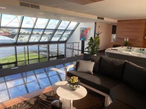 a living room with a couch and a large window at Wellness Dome Penthouse in Kerkrade