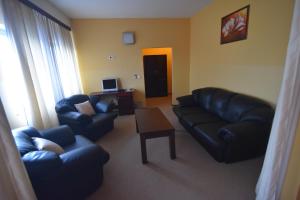 a living room with two leather couches and a table at Motel Atlantis in Prijedor