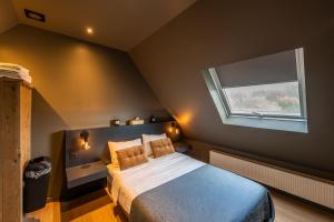 a bedroom with a large bed with a window at M-otel E40 in Wetteren